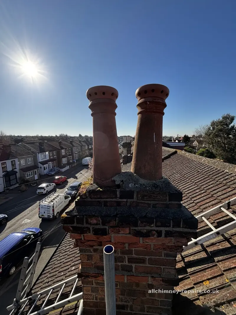 Chimney repair specialist — two leaning 900mm chimney pots with elephant's feet pepper pot clay cappings, flaunching missing from left base, emergency callout, Harold Hill | Allchimney Repairs