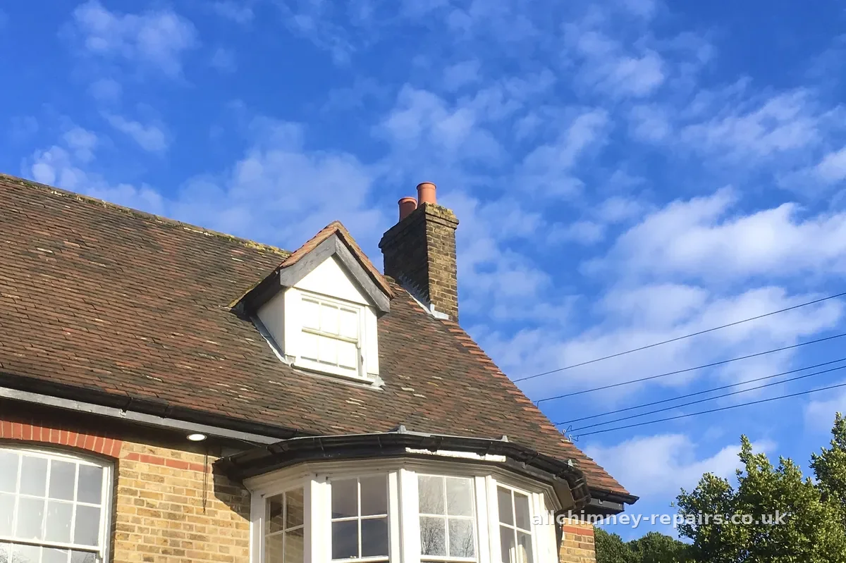 Chimney repair specialist — chimney stack blue sky roofline, Romford | Allchimney Repairs